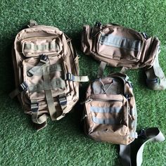 three backpacks sitting on the ground with straps attached to them and one is empty