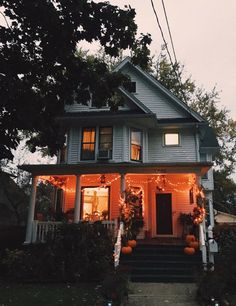 a house decorated for halloween with pumpkins and lights