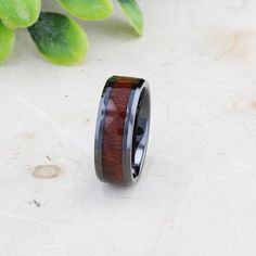 a wooden ring sitting on top of a table next to a plant and some leaves