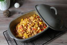 a casserole dish with meat and vegetables in it on a wire cooling rack