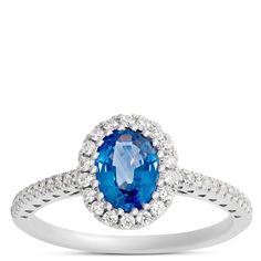 an oval blue sapphire and diamond ring with white diamonds on the band, set in 18k white gold