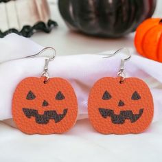 two orange pumpkins with faces on them are sitting next to a white napkin and some other items