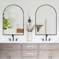 a bathroom with double sinks and mirrors on the wall