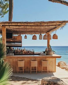 an outdoor bar on the beach next to the ocean