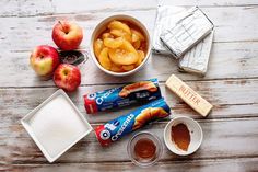 apples, bars, and other ingredients are laid out on a wooden table