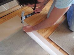 a man is using a pair of scissors to cut paper on the floor with tape