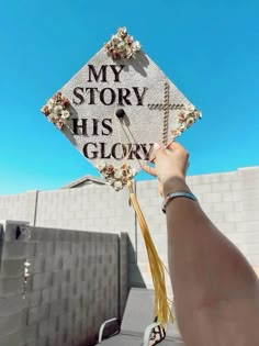 someone holding up a graduation cap that says, my story his glory