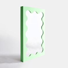 a green box with a mirror on the front and bottom part in the middle that has scalloped edges