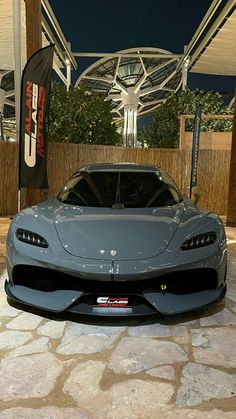 a grey sports car parked in front of a building