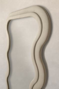 a curved white mirror on a wall