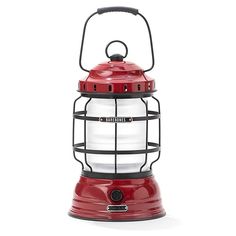 a red and white light with a black handle on the top is sitting in front of a