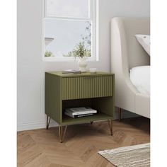 a nightstand with a book on it in front of a white chair and window sill