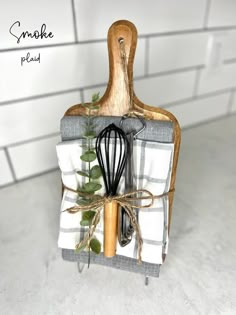 a kitchen utensil holder with a whisk and green leaves on it