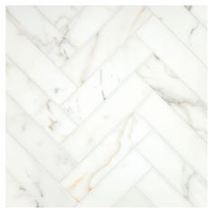 white marble herringbone tile with gold veining on the edges and diagonal lines inlays