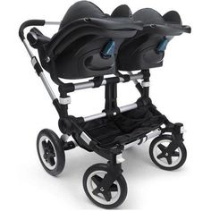 two black strollers with wheels and seats on each side, one is facing the opposite direction