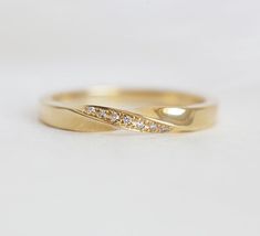 a yellow gold wedding band with white diamonds