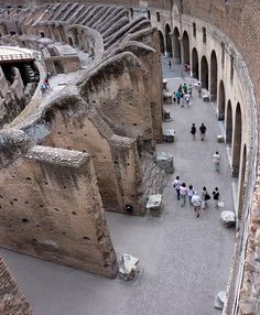 an aerial view of people walking around in the ruins of a roman colossion