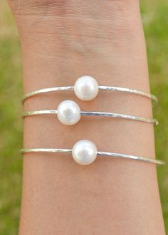 Price is for ONE bangle. Photos may show multiple bangles that are for purchase separately. Classic, chic, white freshwater pearls are always popular! These pearls are smaller than the Edison and Tahitian pearl bangles. Pearls are near round and approximately 9.5-10mm in size. They are not completely flawless and may have small dimples or surface imperfections but overall they look spectacular on a bangle! Wire is 12 gauge and available in your choice of silver or gold filled wire. These are han Pearl Bangles, Pearl Bangle Bracelet, Hawaii Jewelry, Hawaiian Jewelry, Pearl Bangle, Jewelry Pearl, 12 Gauge, Bridesmaid Bracelet, Bridal Bracelet