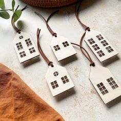 four small wooden houses hanging from brown cord