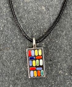 "Vibrant Multi-colored Pendant/Necklace -- Mosaic art pendant handcrafted from tiny ceramic Moroccan tiles in a rainbow of colors -- shades of red, blue, aqua, green, yellow and orange. These bright colors contrast against a backdrop of dramatic black, set in a brass overlaid with sterling silver (.925) rectangular frame. This pendant evokes a festive vibe that is casual and playful, but with a cool, mid-century modern design.  I love creating these unique pieces of jewelry! I play around with m Modern Multicolor Rectangular Jewelry, Modern Multicolor Pendant Necklace, Modern Multicolor Pendant Necklaces, Artisan Multicolor Rectangular Necklace, Modern Handmade Multicolor Necklace, Modern Handmade Multicolor Necklaces, Unique Multicolor Rectangular Necklace, Unique Multicolor Necklace, Rectangular Multicolor Necklaces As Gift