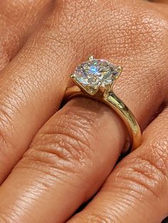 a woman's hand with a diamond ring on top of her finger and an engagement band