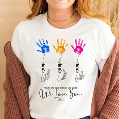 a woman wearing a white t - shirt with three hand prints on it and the words, we love you