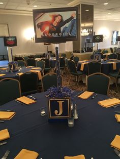 an empty banquet room with blue table cloths and yellow napkins