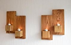 two wooden wall sconces with candles on them in the shape of cubes