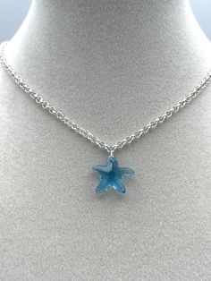 From Our By The Sea Collection :   Beautiful blue and silver come together in this dainty Swarovski crystal pendant necklace. A delightful blue starfish hangs from a sparkly silver plated brass chain. This clear blue glass pendant is small and dainty 3/4 inch wide by 3/4 inch in length. The silver chain is 16-3/4 inches long with a 1-1/2 inch chain extension and a lobster claw clasp. A pretty pendant on a shiny chain makes this necklace a lovely clothing accessory. A fun summer themed item of je Ocean Aesthetic Accessories, Blue Star Charm Pendant Necklace, Blue Pendant Necklace With Star Charm, Blue Sterling Silver Charm Necklace With Lobster Clasp, Blue Star Charm Necklace As A Gift, Blue Star Charm Necklace As Gift, Blue Star Charm Necklace For Gift, Blue Necklace With Star Charm As A Gift, Blue Star Charm Jewelry