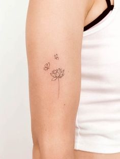 a woman's arm with a small flower tattoo on the left side of her arm