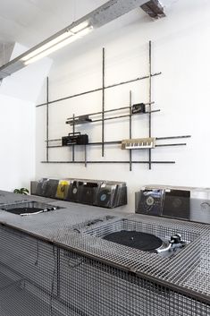 an industrial kitchen with stainless steel counter tops and shelving on the wall behind it