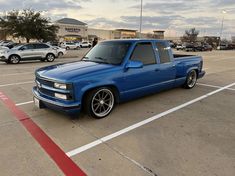 a blue pick up truck parked in a parking lot