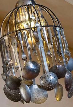 a metal chandelier with spoons and forks hanging from it's center