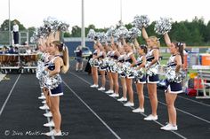 a group of cheerleaders standing on top of a track