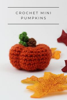 an orange crochet pumpkin with leaves around it