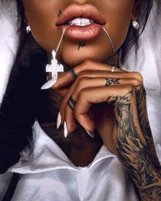 a woman with tattoos and piercings on her face