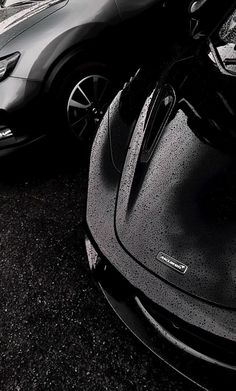 two cars parked next to each other on the side of the road in black and white