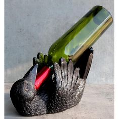 a bird statue with a wine bottle in its beak