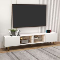 a white entertainment center with a black screen mounted on the wall