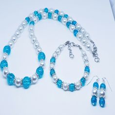 A Lovely Necklace/ Bracelet W/ Earrings Set. This Complete Set Consists Of A Turquoise Crackle Glass Beads With Silver Scallop Spacer Beads And White Pearl Beads. Necklace/Bracelet W/ Earrings To Match. Blue Pearl Jewelry For Jewelry Making, Elegant Single Strand Turquoise Jewelry, Elegant Turquoise Round Jewelry Sets, Elegant Turquoise Single Strand Jewelry, Elegant Turquoise Round Beads Jewelry, Adjustable Round White Jewelry Sets, Elegant Single Strand Turquoise Bracelet, White Faceted Beads Round Jewelry, Elegant Turquoise Jewelry With Spacer Beads