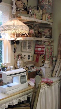 a sewing machine sitting on top of a white table next to a lamp and window