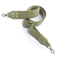 a green leather strap with gold studs on the end and two metal hooks attached to it