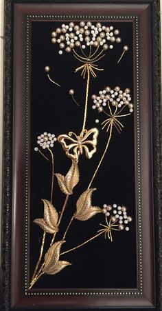 a framed painting with flowers and leaves on it