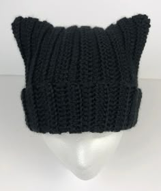 a black knitted cat hat on a mannequin's head with ears