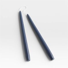 two blue toothbrushes sitting next to each other on a white surface, one is empty