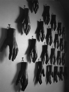 black and white photograph of many hands hanging on the wall