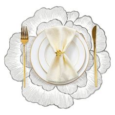 a white and gold place setting on a plate with silver cutlery next to it