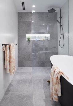 a bathroom with a bathtub, shower and towel rack in the middle of it