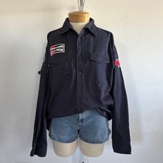 "Embrace a touch of Americana with this vintage Dickies workshirt. Adorned with Route 66 and Champion patches, it's a nod to classic American culture. Made from 100% cotton, this size Large shirt combines durability and style for a timeless addition to your wardrobe. era: 1980s label size: L [please check measurements] fits like: large measurements: bust: 48\" waist: 44\" length: 30\" material: 100% cotton brand/maker: Dickie's condition: excellent vintage condition [ please see photos ] Thanks Cotton Long Sleeve Shirt With Patches, Cotton Long Sleeve Tops With Patches, Vintage Streetwear Shirt With Pockets, Vintage Long Sleeve Tops With Patches, Vintage Long Sleeve Cotton Camp Shirt, Dickies Shirt, Vintage Dickies, American Culture, Large Shirts