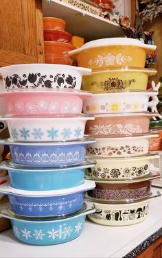 many bowls are stacked on top of each other in different colors and designs, all lined up next to each other